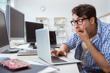 Birçok ekranın önünde oturan bir iş adamı