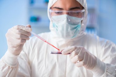 Laboratuvar asistanı hastanede kan örneklerini test ediyor.