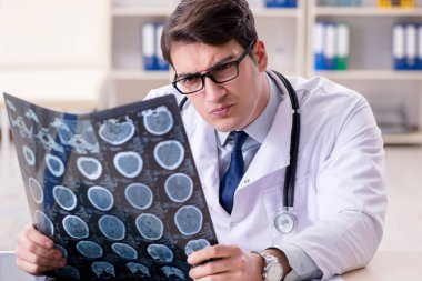 Genç doktor klinikteki röntgen görüntülerine bakıyor.
