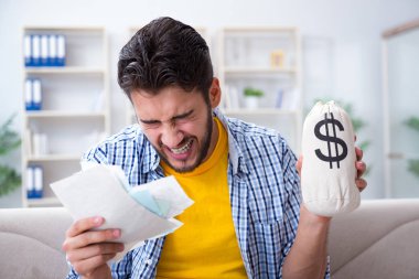 Ödeme yapması gereken faturalara kızgın bir adam.