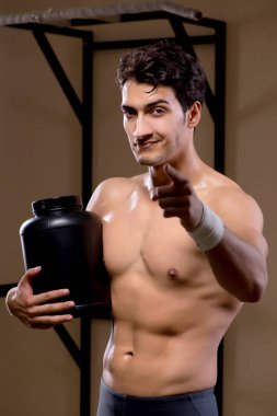 Spor salonunda besin takviyesi olan bir adam.