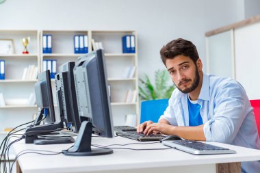 Birçok ekranın önünde oturan bir iş adamı