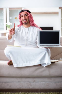 Arap adam evde çalışıyor.