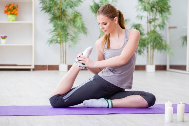 Spor salonunda egzersiz yapan genç bir kadın.