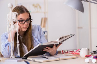 Öğrenci sınıfında oturuyor ve iskelet çalışıyor.