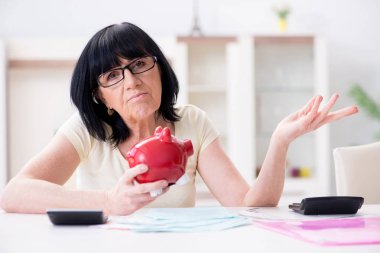 Faturalarını ödemeye çalışan olgun bir kadın.