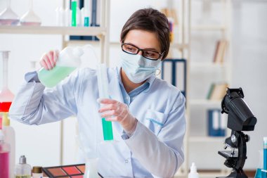 Laboratuar kimyageri güzellik ve makyaj ürünlerini kontrol ediyor.