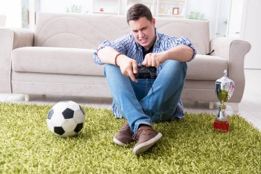 Genç adam evde bilgisayar oyunu oynuyor.