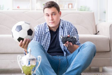 Genç adam evde bilgisayar oyunu oynuyor.