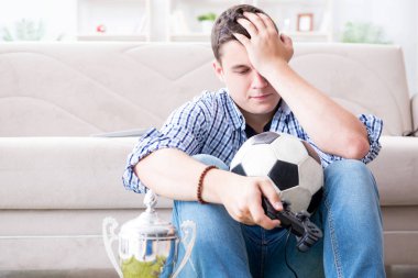 Genç adam evde bilgisayar oyunu oynuyor.