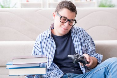 Çalışmayı ve oyun oynamayı dengelemeye çalışan genç öğrenci