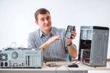 Genç teknisyen atölyede bilgisayar tamir ediyor.