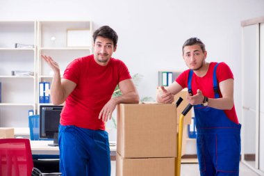 İki müteahhit personel kişisel eşyalarını taşıyor.