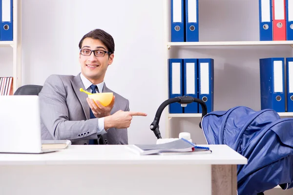 Empresario cuidando al bebé recién nacido en la oficina — Foto de Stock