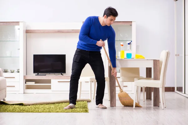 Joven hombre limpieza piso con escoba — Foto de Stock