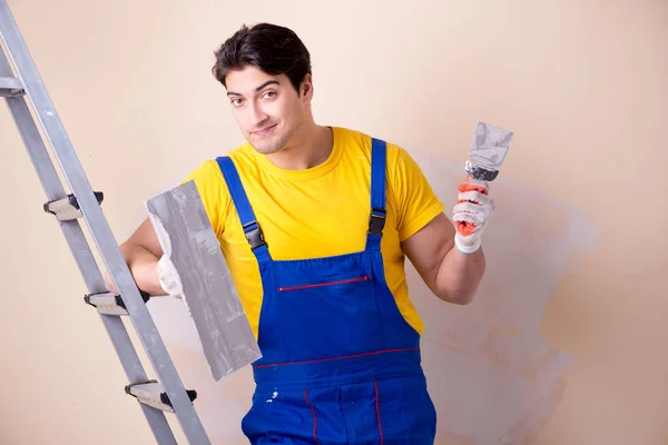 Young contractor employee applying plaster on wall