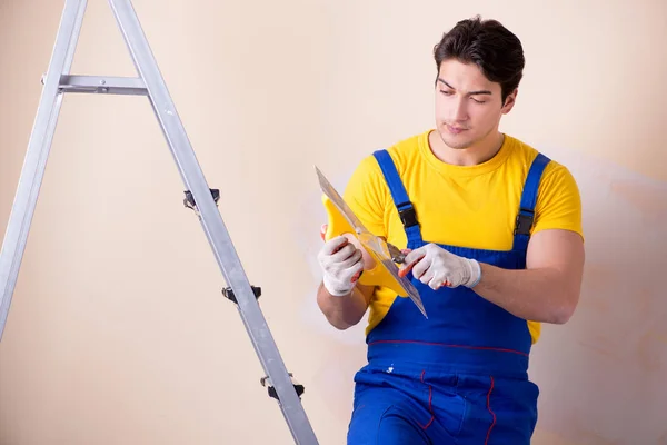 Junger Bauunternehmer verputzt Wand — Stockfoto