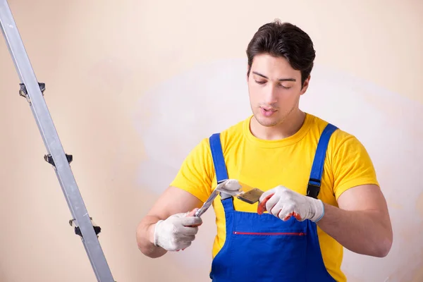 Young contractor employee applying plaster on wall — Stock Photo, Image