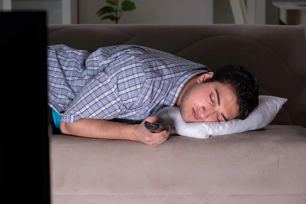 Junger Mann sieht spät abends fern — Stockfoto