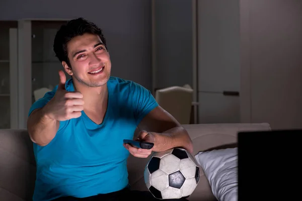 Jovem assistindo futebol tarde da noite — Fotografia de Stock