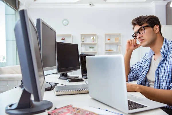 Empresario sentado frente a muchas pantallas — Foto de Stock