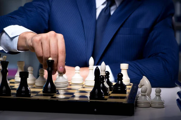 Businessman playing chess in strategy concept — Stock Photo, Image