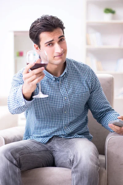 Mladý muž pije víno doma — Stock fotografie