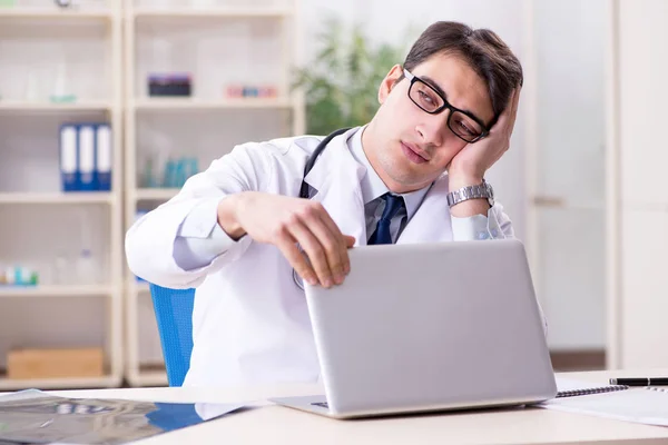 Junger Arzt sitzt im Büro — Stockfoto