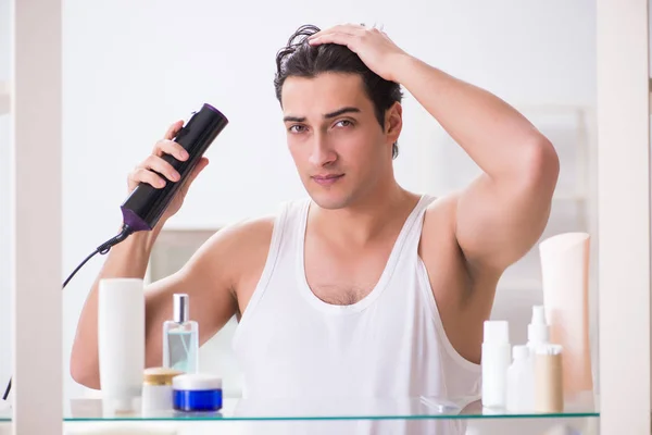 Giovane uomo asciugarsi i capelli al mattino — Foto Stock