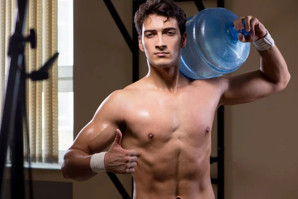 Uomo strappato muscolare con grande bottiglia d'acqua — Foto Stock