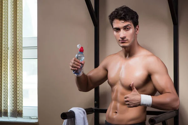 Hombre sediento bebiendo agua en el gimnasio deportivo — Foto de Stock