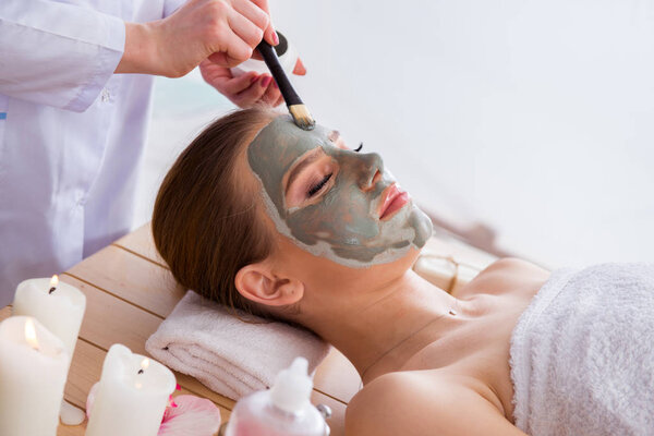 Young woman in spa health concept with face mask