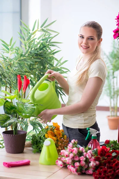 Mujer joven regando plantas en su jardín —  Fotos de Stock