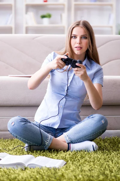 Jonge vrouwelijke student speelt spelletjes thuis — Stockfoto