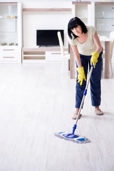 Old mature woman tired after house chores