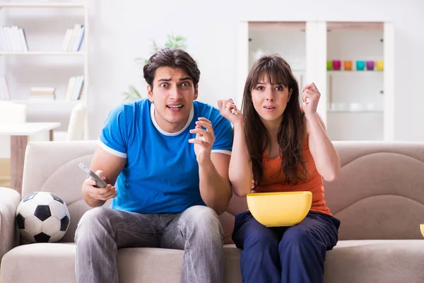Joven hombre viendo fútbol con su esposa en casa — Foto de Stock