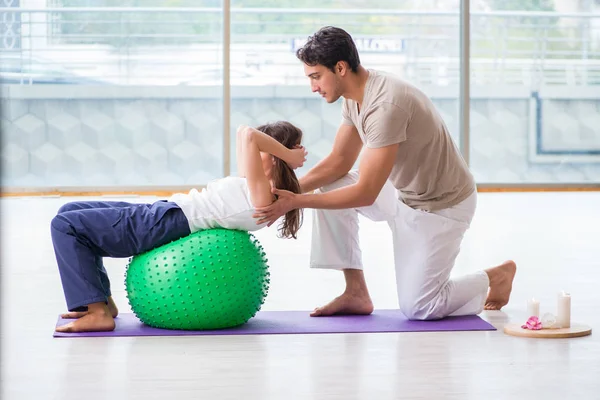 Personal Coach hilft Frau im Fitnessstudio mit Stabilitätsball — Stockfoto