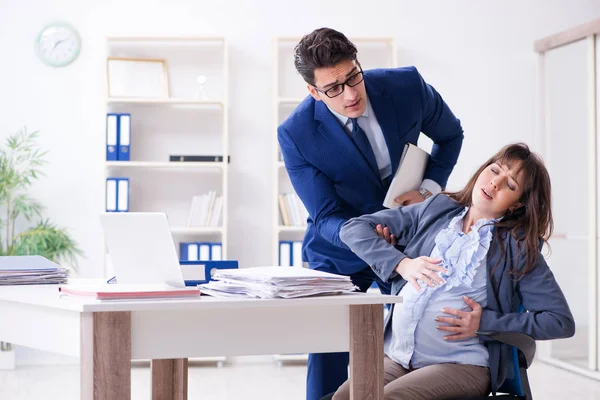 Embarazada mujer luchando en la oficina y conseguir colega él — Foto de Stock