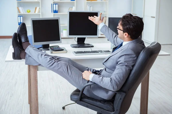 Empresario sentado frente a muchas pantallas — Foto de Stock