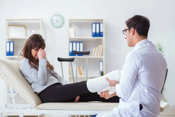 Médecin examinant patient avec jambe cassée — Photo