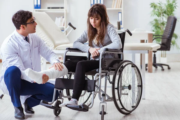 Médico masculino examinando paciente feminina em cadeira de rodas — Fotografia de Stock