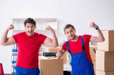 İki müteahhit personel kişisel eşyalarını taşıyor.