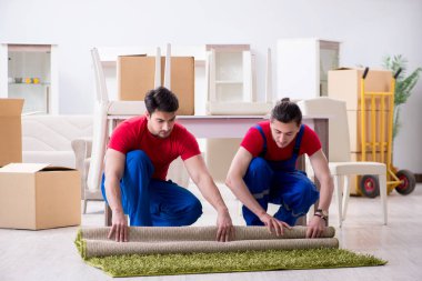 İki müteahhit personel kişisel eşyalarını taşıyor.