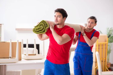 İki müteahhit personel kişisel eşyalarını taşıyor.