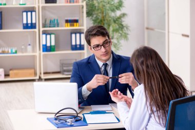 İş adamı doktorla sağlık sorunlarını tartışıyor