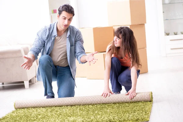 Fiatal család gördülő szőnyeg az új lakás — Stock Fotó