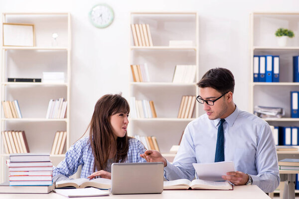 Male lecturer giving lecture to female student