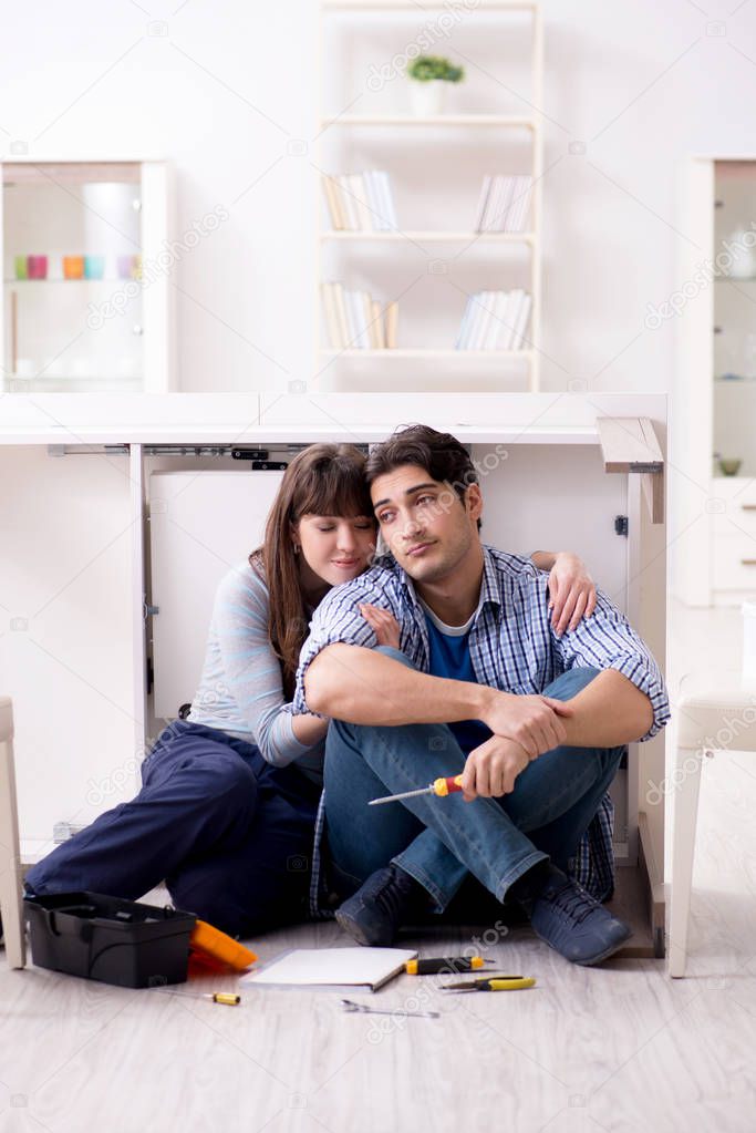 Man and woman assembling furniture at home