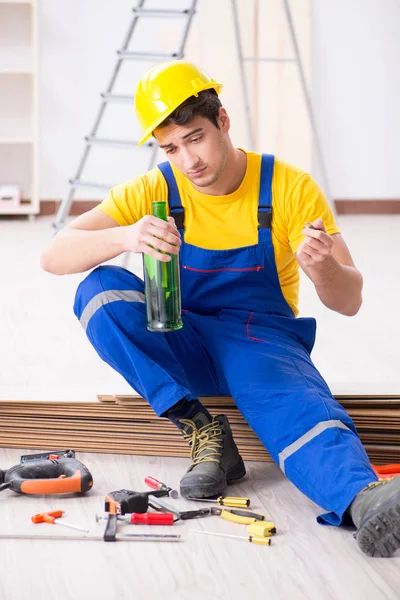 Opravář podlah pije alkohol během přestávky — Stock fotografie