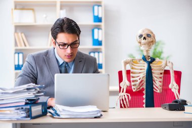 İskeletle çalışan bir iş adamı.